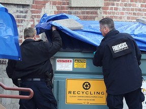 Winnipeg police inspect several dumpsters behind Siloam Mission on Monday that is possibly connected to the murder of two homeless men over the weekend. (Brian Donogh/Winnipeg Sun)
