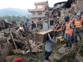 People carry their belongings amidst the rubble of collapsed houses in Bhaktapur, on the outskirts of Kathmandu, on Monday, two days after a 7.8 magnitude earthquake hit Nepal. Nepalis started fleeing their devastated capital after an earthquake killed more than 3,800 people and toppled entire streets, as the United Nations prepared a "massive" aid operation. (AFP PHOTO/PRAKASH MATHEMA)