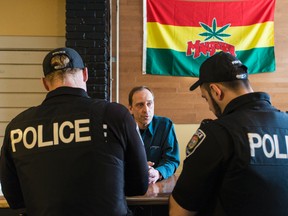 BuzzOn owner Wayne Robillard speaks with Ottawa Police Officers at his Montreal Rd. vapour lounge on Monday, April 27, 2015. Errol McGihon/Ottawa Sun/Postmedia Network