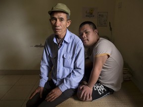 63-year-old former soldier, Nguyen Hong Phuc, sits on the bed with his son Nguyen Dinh Loc, 20, who is recovering from tumour surgery at Friendship village, a hospice for Agent Orange victims, outside Hanoi April 8, 2015. Nguyen Dinh Loc has serious mental and physical problems that his family and doctors link to his father's exposure to Agent Orange. His father joined the military after the U.S. army stopped using Agent Orange in 1971, but lived in areas heavily contaminated by it, including near Danang airport, where the chemical defoliant was stored.  REUTERS/Damir Sagolj