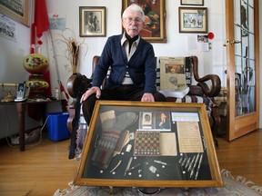 Poland native and Carrying-Place, Ont. resident Eugene Moshynski, 92, who survived after he was placed in the Nazi concentration camp Dachau for five years, poses along items he smuggled from the camp on the eve of the anniversary of the Dachau Liberation Tuesday, April 28, 2015.  -  Jerome Lessard/Belleville Intelligencer/Postmedia Network