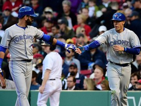 Toronto Blue Jays designated hitter Jose Bautista (left) congratulates shortstop Ryan Goins after scoring during MLB play against the Boston Red Sox at Fenway Park Tuesday. (Bob DeChiara/USA TODAY Sports)