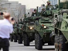 Members of the Canadian Forces ride light-armoured vehicles (LAV) to Parliament Hill during the National Day of Honour ceremony in Ottawa in this May 9, 2014 file photo. (REUTERS/Blair Gable)