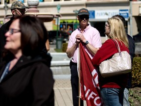 A man holding a Unifor flag attends the day of mourning, which took place on Tuesday morning in Museum Square in Woodstock. (BRUCE CHESSELL/Sentinel-Review)