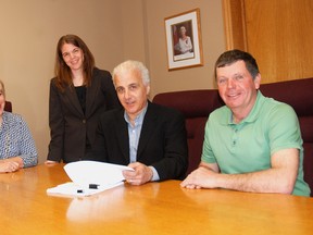 Dutton/Dunwich Administrator Laurie Spence Bannerman, left and Tara Oudekerk, legal counsel tp Dutton/Dunwich wtness the signing of the Highland Estates subdivision agreement by Sandy Acchione of Amjen Realty. On the right is Dutton/Dunwich Mayor Cameron McWilliam.