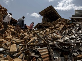 Local villagers walk amid debris at a devastated area following Saturday's earthquake, at Asslang village, in Gorkha, Nepal April 29, 2015. The death toll from the devastating earthquake in Nepal four days ago passed 5,000 on Wednesday as officials conceded they had made mistakes in their initial response, leaving survivors stranded in remote villages waiting for aid and relief.    REUTERS/Athit Perawongmetha