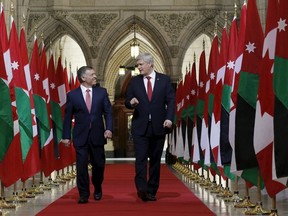 Canada's Prime Minister Stephen Harper (R) and Jordan's King Abdullah walk in the Hall of Honour on Parliament Hill in Ottawa April 29, 2015. REUTERS/Chris Wattie