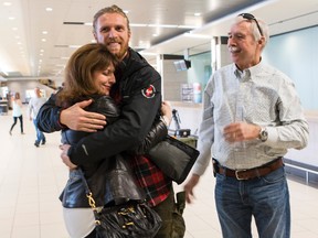 Connie Carson (left) hugs her son Matt Carson as dad Jim looks on at the Ottawa Airport following Matt's return from the earthquake ravaged area of Nepal. Matt and some of his teammates from charity trekking group Dream Mountains Foundation returned to Ottawa on Wednesday April 29, 2015. Errol McGihon/Ottawa Sun/Postmedia Network