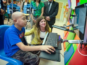 Isaac Valdez-Cadet, 8, with Minister Rona Ambrose at CHEO Wednesday. Ambrose helped the hospital launch a new campaign and website promoting vaccination in kids. DANI-ELLE DUBE/OTTAWA SUN
