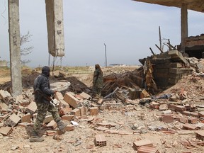 Islamist rebel fighters walk in Qarmeed camp, after taking control of the area, in Idlib province, Syria April 27, 2015. A coalition of Islamist rebels seized the army base in northwestern Syria at dawn on Monday after a suicide bomber from al Qaeda's Nusra Front drove a truck packed with explosives into the compound and blew it up. REUTERS/Ammar Abdullah