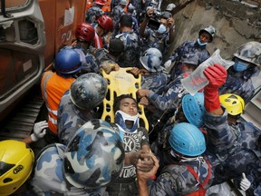 Earthquake survivor Pema Lama, 15, is rescued by the Armed Police Force from the collapsed Hilton Hotel, the result of an earthquake in Kathmandu, Nepal on April 30, 2015. (REUTERS/Adnan Abidi)
