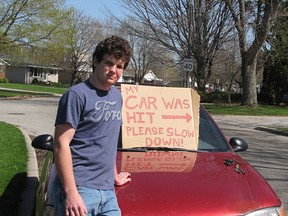 Sean Van Deriviere of Chatham decided to post his own traffic sign on Vanier Drive after his vehicle was struck. Parts of his car, displayed on the hood, were found several feet away.  (Blair Andrews/Chatham This Week)