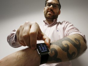 Reuters journalist Matt Siegel inputs his passcode onto his Apple Watch as his tattoos prevent the device's sensors from correctly detecting his skin, in Sydney, Australia, April 30, 2015. REUTERS/Jason Reed