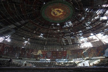 A photographer takes pictures inside the crumbling main hall of the Memorial House of the Bulgarian Communist Party on mount Buzludzha. REUTERS/Stoyan Nenov