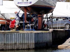 High water marks show on a dock at the Brockville Yacht Club as Pat McMahon applies a coat of antifouling paint to his sailboat Tenacious III on Thursday, April 30, 2015 in Brockville, Ont. Darcy Cheek/Brockville Recorder and Times/Postmedia Network