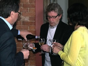 Lubomyr Luciuk, left, poors a glass of wine for David Lawrason, middle, during a wine tasting at a restaurant in Kingston. Lawrason, who is one of Canada's top wine critics travelled to Kingston as a guest speaker for "The Royal Winers" about the Prince Edward County's wine. (James Paddle-Grant/For The Whig-Standard)