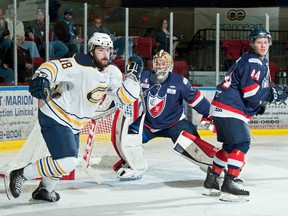 Vinny Post of Carleton Place, seen here in front of Longueuil goaltender Kevin Darveau and defenceman Jonathan Fillion, had a big assist on the game-winning goal, scored by linemate Stephen Baylis, in the Canadians' 4-2 win against Longueuil at the Fred Page Cup on Wednesday in Cornwall. Carleton Place improved to 2-0 at the tourney. Robert Lefebvre/Special to the Cornwall Standard-Freeholder/Postmedia Network