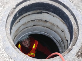 A sewer worker takes a camera inside a sewer main. (file photo)