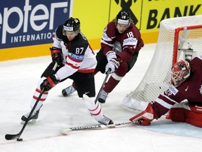 Canada's Sidney Crosby challenges Latvia's Rodrigo Abols and goalkeeper Ervins Mustukovs (L-R) during their Ice Hockey World Championship game at O2 arena in Prague, Czech Republic May 1, 2015. REUTERS/David W Cerny