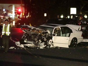 A Los Angeles County Sheriff's Deputy walks past a severely damaged vehicle at the scene of a four-car crash involving Olympic gold medalist and reality TV star Caitlyn Jenner in Malibu, California, February 7, 2015. REUTERS/Jonathan Alcorn