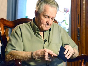 Veteran Art Boon checks over his passport before leaving Friday afternoon for the Netherlands with his son and his grandson. (SCOTT WISHART, The Beacon Herald)