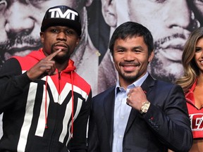 WBC/WBA welterweight champion Floyd Mayweather Jr. (L) and WBO welterweight champion Manny Pacquiao pose during a news conference at the KA Theatre at MGM Grand Hotel & Casino on April 29, 2015 in Las Vegas, Nevada. (AFP PHOTO / JOHN GURZINSKI)
