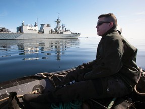 A crewman from the frigate HMCS Toronto looks back at his ship from a zodiac while on manoeuvres on Frobisher Bay in the Canadian Arctic, Aug. 19, 2009. (ANDY CLARK/Reuters)