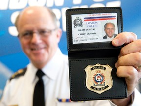 Retired police chief Brad Duncan shows off his retirement badge at a reception at London police headquarters to celebrate his final day at the helm of the force. Duncan served on the London force for 35 years, the last five as chief. (CRAIG GLOVER, The London Free Press)