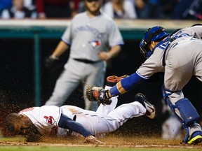 Cleveland Indians centre fielder Michael Bourn dives into home  plate as he is tagged out by Toronto Blue Jays catcher Russell Martin in the fourth inning at Progressive Field. (Rick Osentoski/USA TODAY Sports)