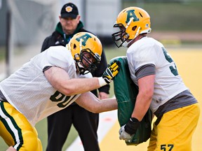 Peter Kozushka, left, runs a drill with David Beard, right, during the University of Alberta Golden Bears football spring camp at Foote Field on Friday. (Codie McLachlan, Edmonton Sun)