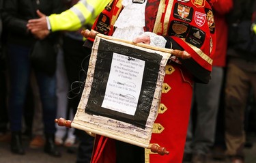 A ceremonial town crier holds a scroll after announcing the birth of a baby girl to royal fans and members of the media outside the entrance to the Lindo wing of St Mary's Hospital in London, May 2, 2015.  REUTERS/Cathal McNaughton