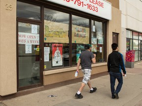 Two men walk past the recently opened BuzzOn vapour lounge in Ottawa on Friday, May 1, 2015. (Errol McGihon/Ottawa Sun/Postmedia Network)
