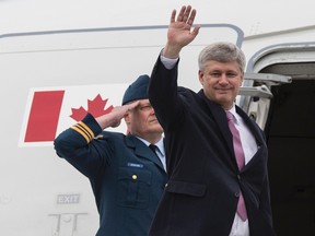 Prime Minister Stephen Harper waves as he boards a Royal Canadian Air Force plane in Ottawa on May 1, 2015. Harper is travelling to the Netherlands to participate in the 70th anniversary of their liberation. (Errol McGihon/Postmedia Network)