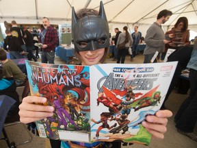 Nina Cumming, 9, dressed as Batgirl, looks over a comic book during Free Comic Book Day at Happy Harbor Comics, 10729 - 104 Ave., in Edmonton, Alta. on Saturday May 2, 2015. The store expected to give away 17,000 comic books. David Bloom/Edmonton Sun/Postmedia Network
