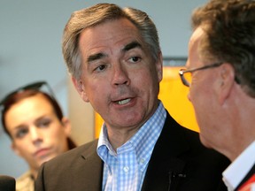 Alberta Premier Jim Prentice (L) chats with the media alongside PC Candidate Gordon Dirks at Dirks campaign office in Calgary, Alta. on Saturday May 2, 2015. Stuart Dryden/Calgary Sun/Postmedia Network
