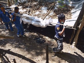 Rescue workers recover human remains from an abandoned camp in Thailand's southern Songkhla province May 1, 2015.  REUTERS/Daily News