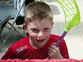 Eight-year-old Aidan Crawford is impressed with the cake baked specially to celebrate the one-year countdown to the 2016 U19 women's world floorball championships in Belleville during a demonstration and information session Saturday at Quinte Mall. (Paul Svoboda/The Intelligencer)