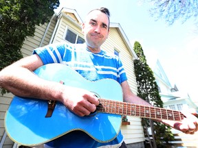 Sean Hogan, lead singer for Seanster and the Monsters, strums a guitar at his West End home on Sunday, May 4, 2015. Hogan earned an honourable mention in the 2014 International Songwriting Competition in the Children's Music category. (Kevin King/Winnipeg Sun)
