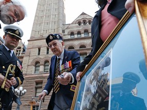 A veteran, who would not give his name, points out the medals won by Robert Hampton Gray  and held by a friend, Cindy Corcoran. Gray was killed in the last days of the Second World War and awarded a Victoria Cross. (MICHAEL PEAKE, Toronto Sun)