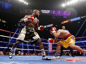 US boxer Floyd Mayweather Jr., (L) and Manny Pacquiao of the Philippines fight during their welterweight unification boxing bout at the MGM Grand Garden Arena in Las Vegas, Nevada on May 2, 2015. (AFP PHOTO / JOHN GURZINKSI)