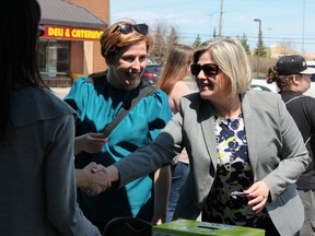 Andrea Horwath, leader of the Ontario MPP, and Kingston Coun. Mary Rita Holland, president of the Ontario New Democratic Party, stop by a barbecue hosted by EMMO Kingston in Kingston on Saturday. (Steph Crosier/The Whig-Standard)