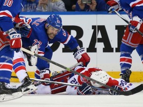 Rangers defenceman Dan Boyle gives Troy Brouwer of the Capitals an extra shot during Game 2 of the Eastern Conference semifinal on Saturday. Boyle had a power-play goal in the first period of the game. (Getty Images/AFP)