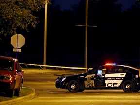 A police officer stands near the suspects' vehicle after a shooting outside the Muhammad Art Exhibit and Contest sponsored by the American Freedom Defense Initiative in Garland, Texas May 3, 2015.    REUTERS/Mike Stone