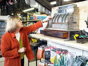 Pat McGee shows off a cash register on display as part of the 150th anniversary celebrations of Van Tuyl & Fairbank Hardware in Petrolia. (BRENT BOLES, Postmedia Network)