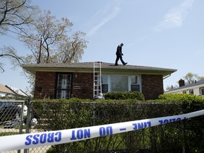 A NYPD officer is seen on the roof of a house while police search for the weapon used to shoot New York City plainclothes police officer Brian Moore at the Queens Village, in New York May 3, 2015. Moore, who was seriously injured when he was shot in the head on Saturday while attempting to question a man, has died. REUTERS/Eduardo Munoz