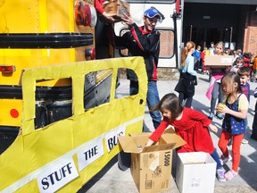 Natalie Kester, a senior kindergarten student at St. Patrick’s in Dublin, places an item in a box for the 8th annual Huron-Perth Catholic District School Board “Stuff That Bus” campaign last Wednesday, April 29, while Grade 8 student Jack Dixon, of St. Columban, hands a box up to Georgia Schoonderwoerd.  ANDY BADER/MITCHELL ADVOCATE