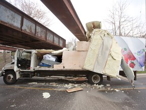 Talbot St traffic was snarled for several hours after a dairy delivery truck from Toronto failed to fit under the train bridge south of Oxford St. The bridge has a clearance of 3.3 meters. (DEREK RUTTAN, The London Free Press)