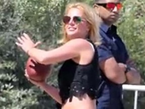 Screen grab showing Britney Spears playing football on the beach in Malibu. (TMZ video)