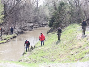 Gino Donato/The Sudbury Star
Members of Greater Sudbury Police Service comb the banks of Junction  Creek on Monday afternoon.