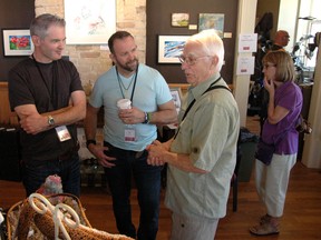 Jared Smith (left) and Jason Puhr talk art with photographer Earle Barr (right) during the Oxford Studio Tour Saturday at the Station Arts Centre. (CHRIS ABBOTT/TILLSONBURG NEWS)